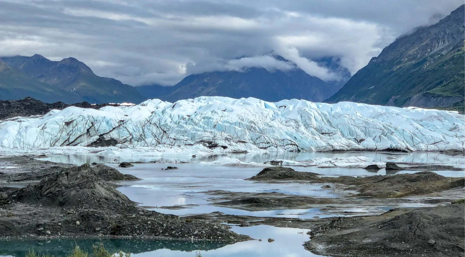 The Matanuska Glacier's snout, meltwater ponds and moraine below the Chugach Mountains