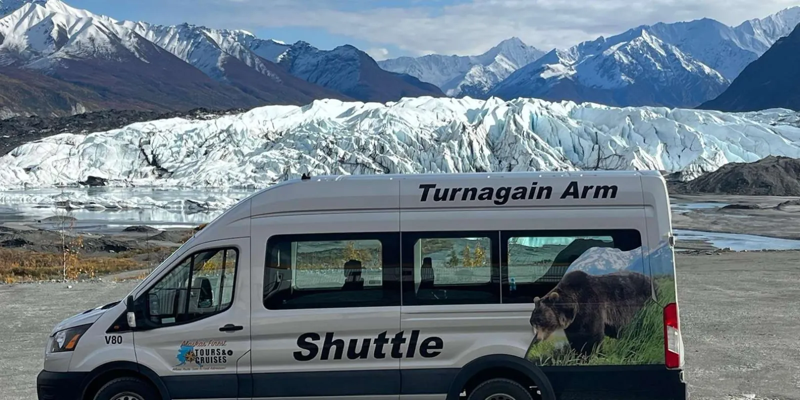 The tour shuttle van parked with the Matanuska Glacier and Chugach peaks behind