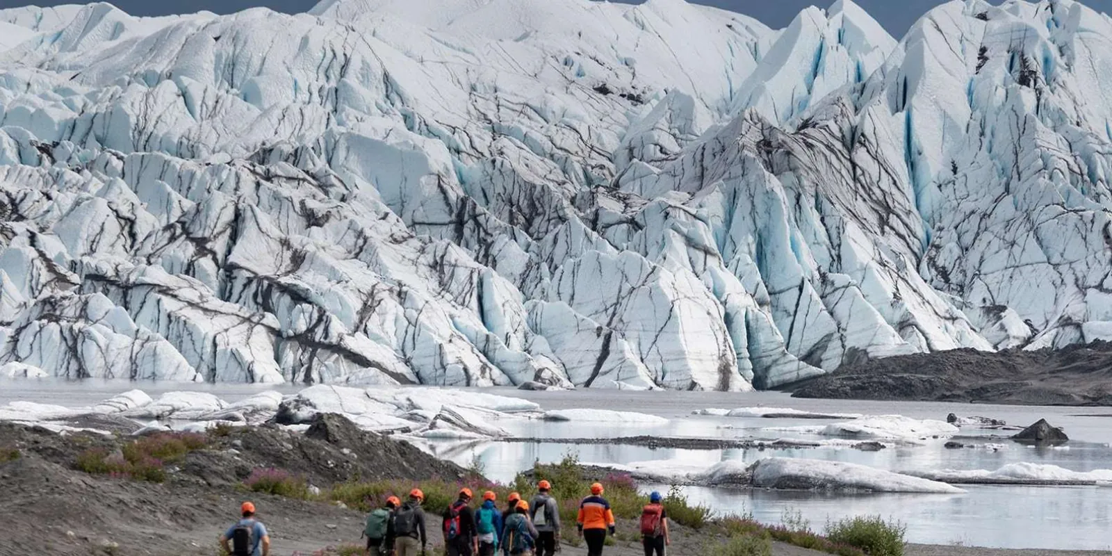 Guided group walking the shoreline below the Matanuska Glacier's terminus
