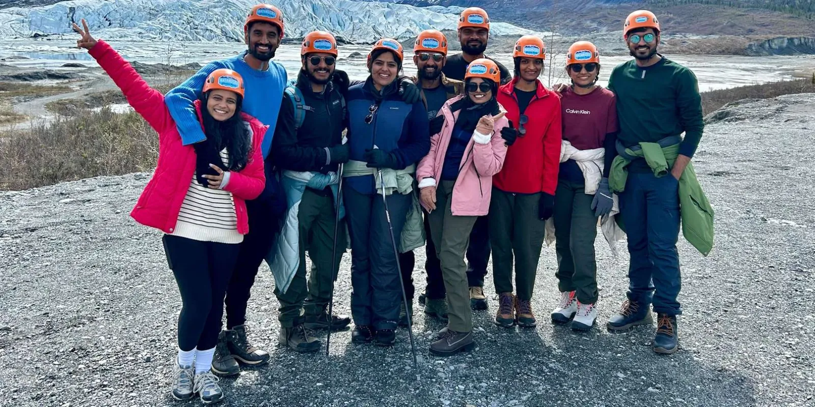 Tour group in orange helmets posed on the moraine below the Matanuska Glacier
