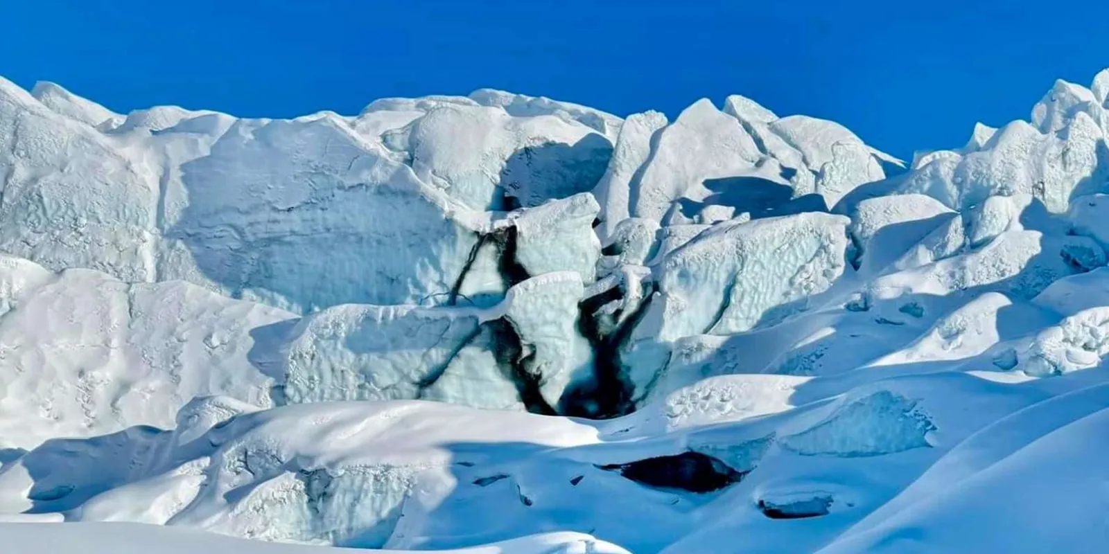 Sunlit crevasse field across the glacier's upper surface