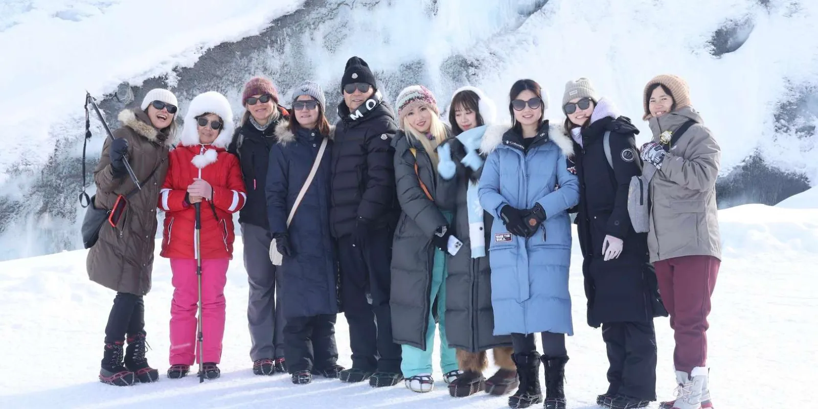 Winter tour group in parkas posed on the snow below the Matanuska Glacier